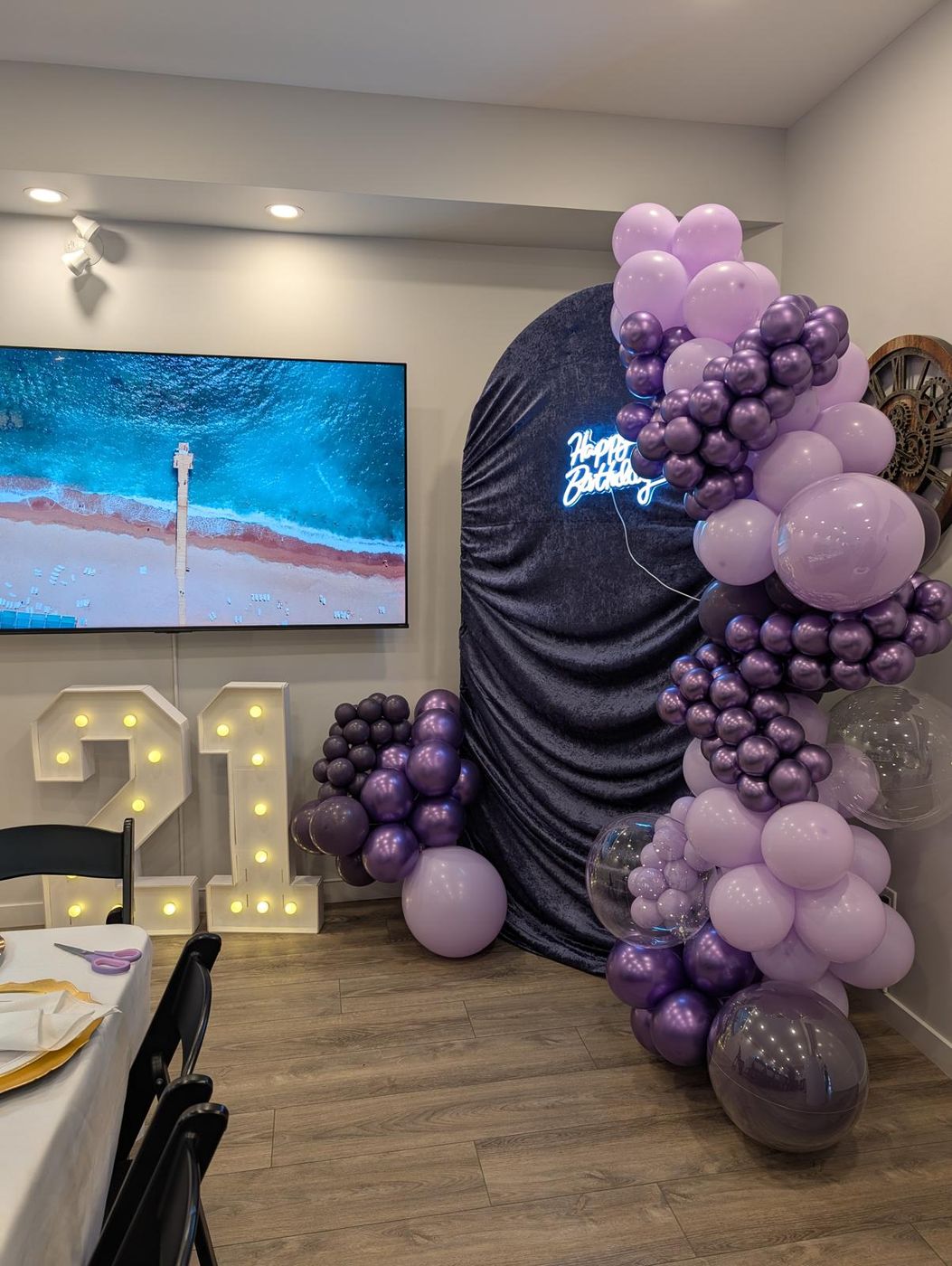 Lavender tablescape with gold chargers and Happy Birthday balloon backdrop